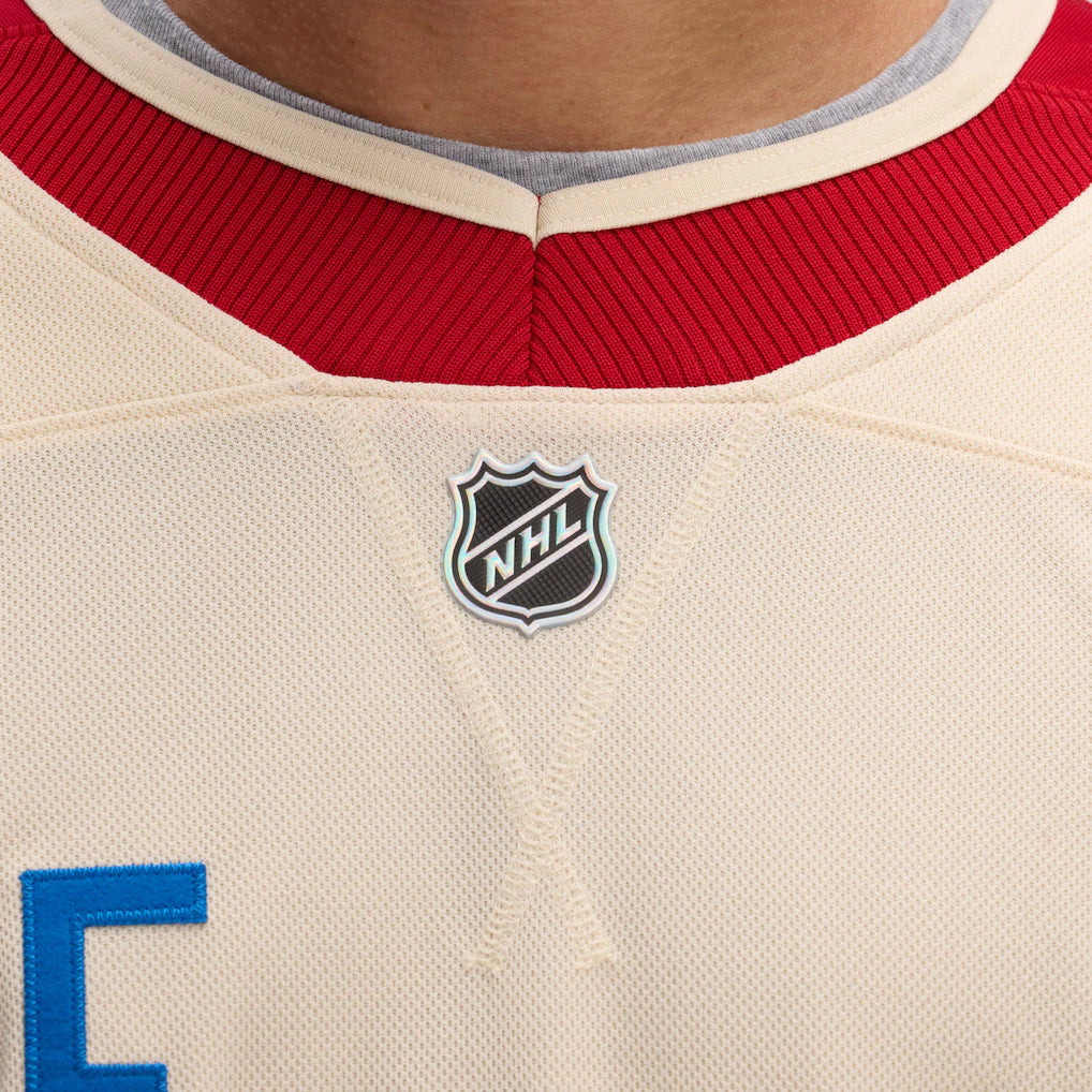 Close-up of a hockey jersey with NHL logo on beige fabric.