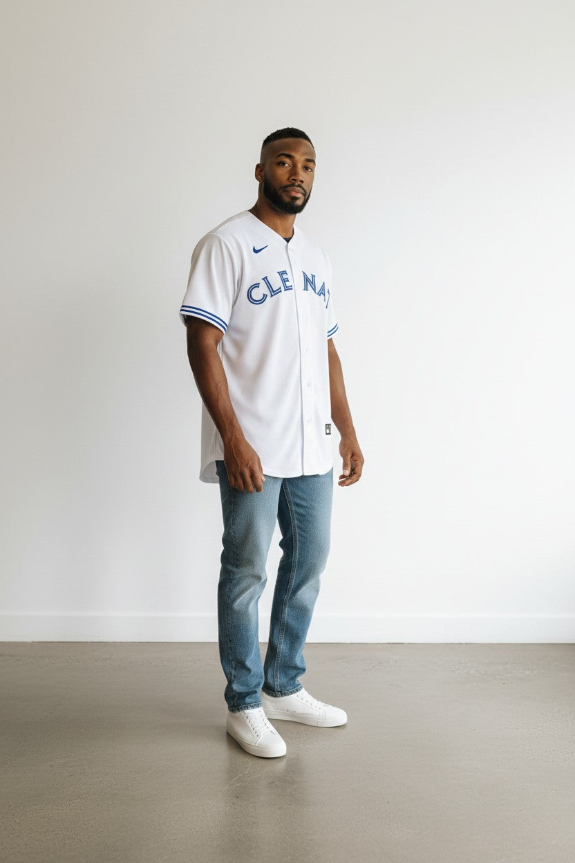Man wearing a white sports jersey with blue accents against a plain background